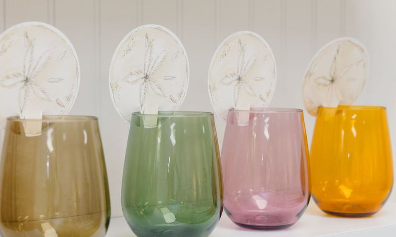 Row of colored glass tumblers in olive, green, blush and amber