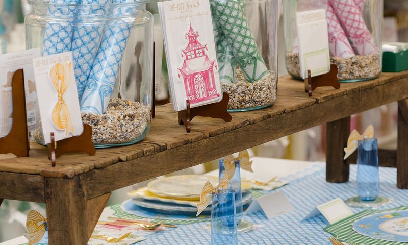 Blue and green table setting beneath a display of gift wrap